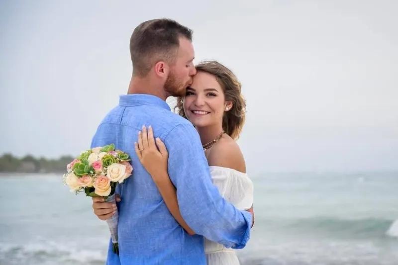 Bride and groom kiss on Caribbean beach